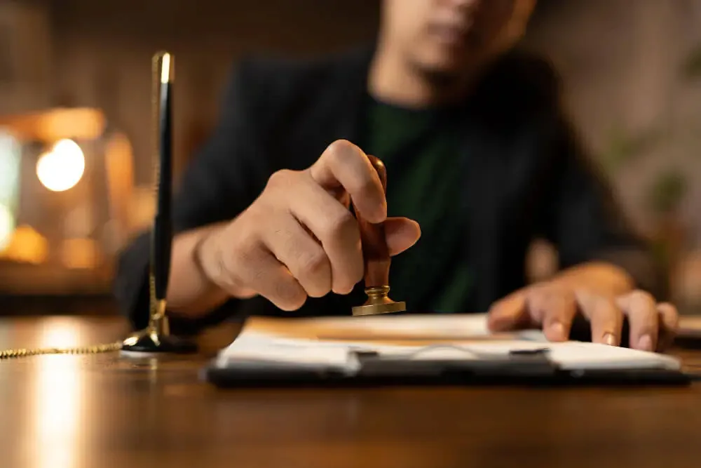 Vakreviewer in ons kantoor zet de stempel onder een afgeronde beëdigde vertaling